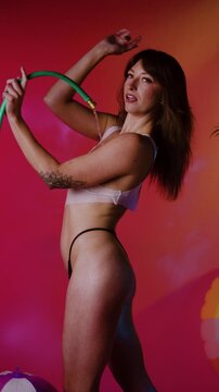 Woman Posing With Neon Hoop Under Pink Lighting