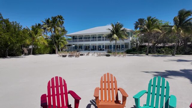 Historic colonial style house with a sandy beach and colorful chairs at Islamorada, Florida Keys