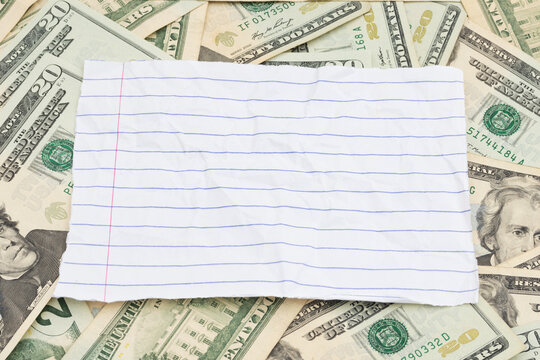 Blank lined paper with twenty dollar bill cash