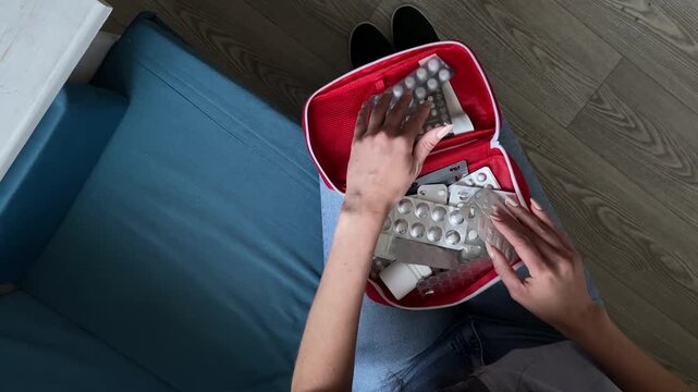 First aid kit. A woman is sitting. Jeans. Slow motion video. High quality 4k footage