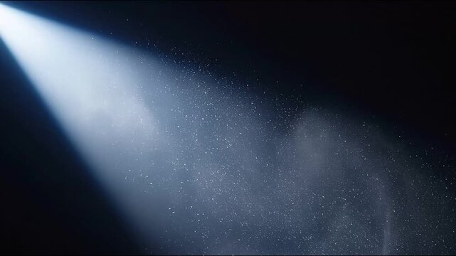 Bright spotlight beam illuminates dust particles in dark atmosphere, abstract background
