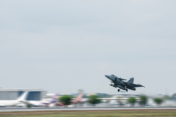 Obraz premium Supersonic fighter jet moving in airport on technology background