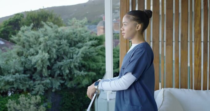 African American nurse 20s in scrubs resting on balcony railing with camera reframing, copy space