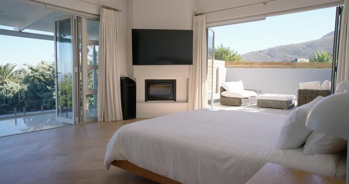Camera is starting slow pass across master bedroom, revealing bed and balcony to show mountain