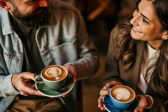 Happy couple enjoying coffee date with latte art