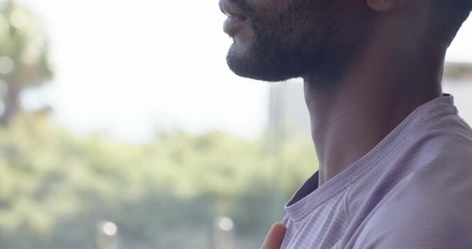 Man pressing hand to chest, lifting chin, practicing slow breathing by window, copy space