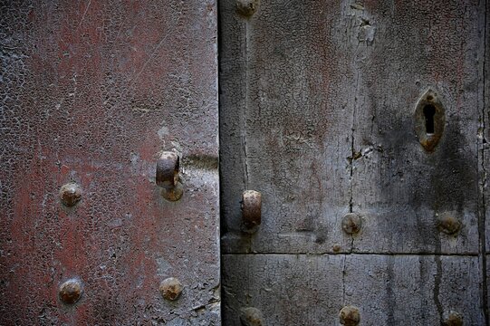 Antique weathered metal door with rusty studs in Calascibetta Sicily, Italy.