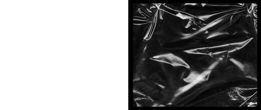 Crumpled black plastic texture with glossy highlights, wrinkled dark cellophane background, shiny synthetic material surface for edgy graphic design