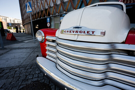Vintage Chevrolet truck front grill and hood emblem on a classic red and white automobile in Katowice, Poland