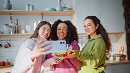 Obraz premium Culinary bloggers recording cellphone video holding bowl with salad closeup.