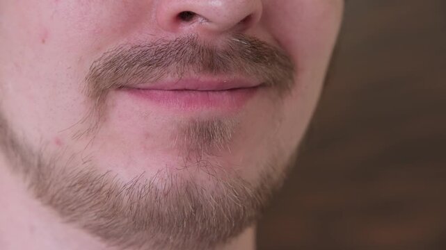 Close-up of a man with a beard and mustache smiling