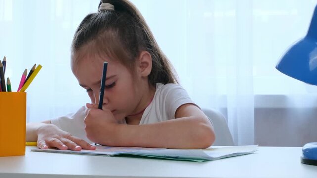 Child studying at home, writing homework, education and learning concept