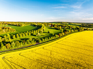 Obraz premium Rapeseed Fields and Farms over Horsebridge nad Stockbridge from a drone, Hampshire, England