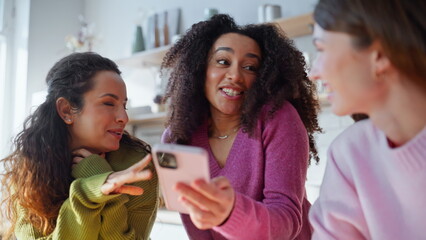 Fototapeta premium Girls friends browsing mobile phone reading social media message home closeup.