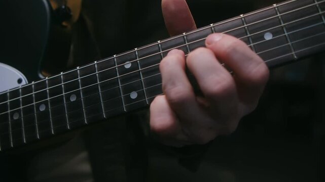 Musician hand playing different solo and notes on fretboard of black electric guitar, perfect for music related projects, tutorials, artistic content. Guitarist playing solo on electric guitar