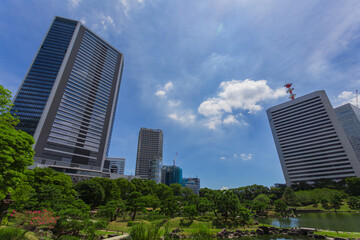 Fototapeta premium Beautiful rock arrangements and cityscape viewed across the pond at Kyu-Shiba-rikyu Gardens September 2023