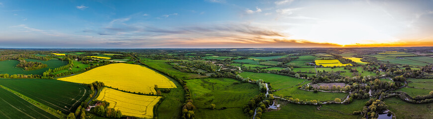Obraz premium Sunset of Fields and Farms over Horsebridge nad Stockbridge from a drone, Hampshire, England
