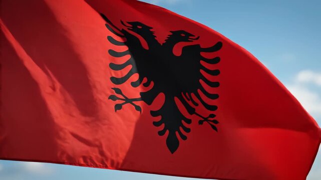 Albanian flag waving in sky