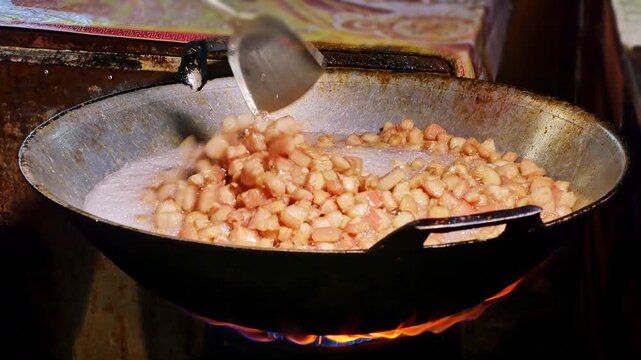 Fresh pork skin pieces frying in bubbling oil, capturing the essence of homemade crispy pork rind snack.