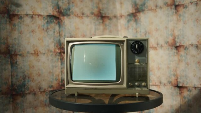 Experience the charm of a retro television displaying grainy black and white static. This quaint setup evokes nostalgia, featuring warm lighting and classic decor. Perfect for a Halloween vibe
