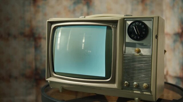 A retro television displays a flickering static screen in a warmly lit room. This vintage piece evokes memories of past broadcasts, capturing the charm of old entertainment technology