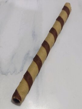 Close up of crispy chocolate wafer sticks with spiral chocolate cream pattern isolated on white background