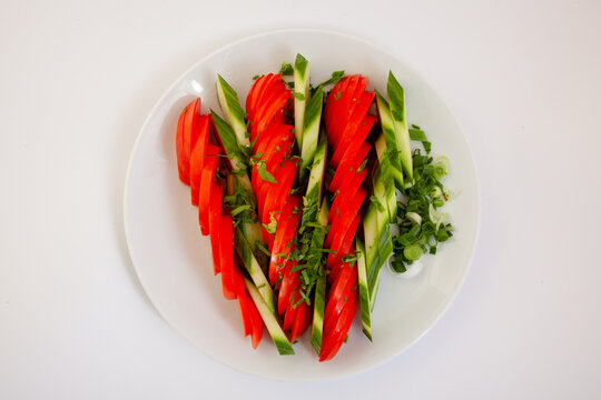 Fresh Sliced Tomatoes and Cucumbers with Green Onions and Herbs on a White Plate. Healthy Summer Salad, Vegan Food, Organic Vegetables, Clean Eating Concept