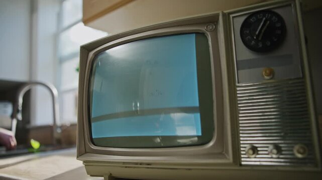 Step into a cozy kitchen where a retro television set fills the space with nostalgic vibes as it displays grainy black and white static. Perfect for a Halloween night ambiance