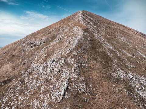 Rtanj mountain showing its pyramid like peak, rugged slopes, and bare trees under a clear sky in eastern Serbia
