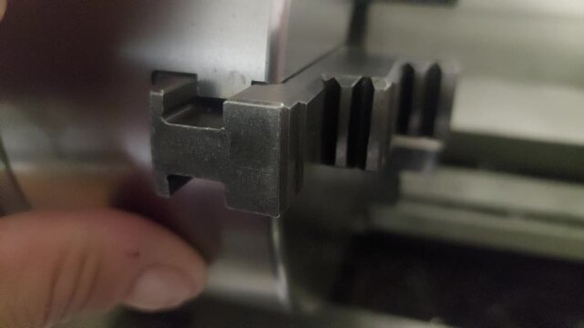 Close-up of adjusting the jaw of a lathe chuck in a machine shop