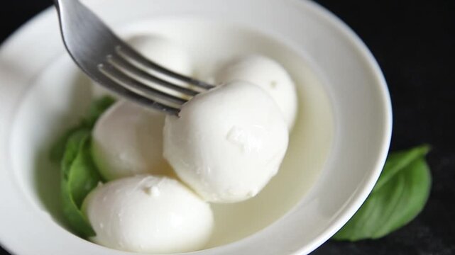Mini mozzarella or mini burrata soft, young cheese lunch or dinner tasty snack organic fresh and gourmet food background on the table rustic food top view copy space