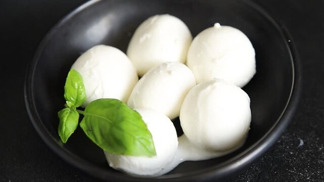Mini mozzarella or mini burrata soft, young cheese lunch or dinner tasty snack organic fresh and gourmet food background on the table rustic food top view copy space