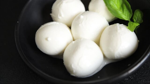 Mini mozzarella or mini burrata soft, young cheese lunch or dinner tasty snack organic fresh and gourmet food background on the table rustic food top view copy space
