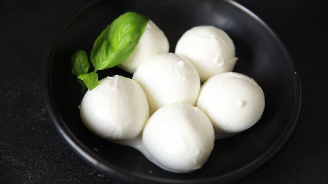 Mini mozzarella or mini burrata soft, young cheese lunch or dinner tasty snack organic fresh and gourmet food background on the table rustic food top view copy space