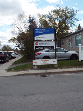 Gatineau, Quebec, Canada &ndash; May 7, 2026: A hospital sign for "H&ocirc;pital de Hull" stands on a street corner with parked cars on  Bd Lionel-&Eacute;mond.