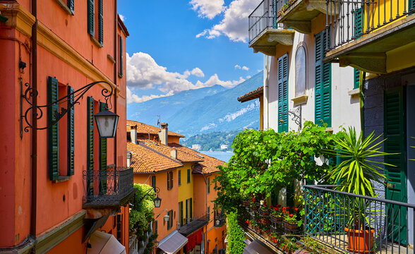 Bellagio village at lake Como near Milan Italy, region Lombardy. Famous street with paving stones stairs and cosy restaurants during sunrise with glowing lanterns and green plants on old houses walls.