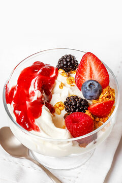 Plain yogurt with berries, granola, and berry jam
