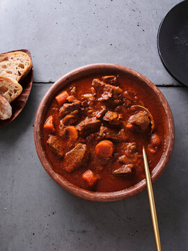 Slow cooked shredded beef served with fresh bread on a simple table setting in a home kitchen during afternoon hours