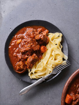Slow cooked shredded beef served with pasta at a kitchen table during dinner time