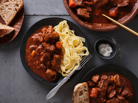 Slow cooked shredded beef served with pasta and fresh bread at a cozy dinner table during evening hours