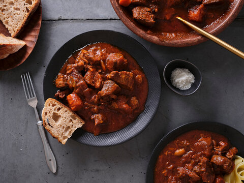 Slow cooked shredded beef served with bread on a gray table