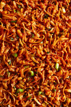 Full-frame top view of spicy kimchi with napa cabbage and green onions.