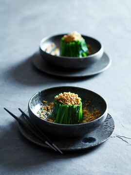 Japanese Horenso Gomae spinach salad with sesame dressing served on dark ceramic plates.