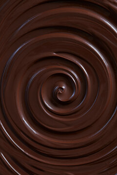 Smooth, glossy liquid dark chocolate swirling in a rich spiral, showcasing a luxurious melted chocolate texture in close-up.