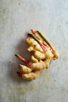 Fresh ginger root photographed on a light stone surface with copy space.