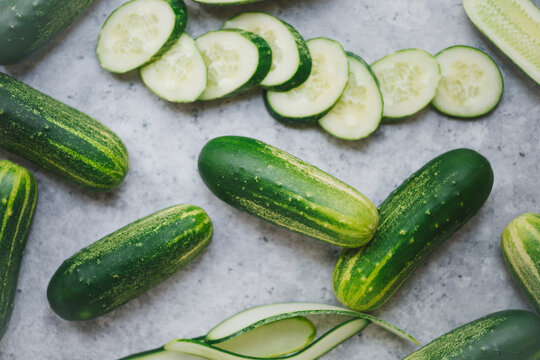 Freshly picked green Cucumbers on a marble kitchen surface