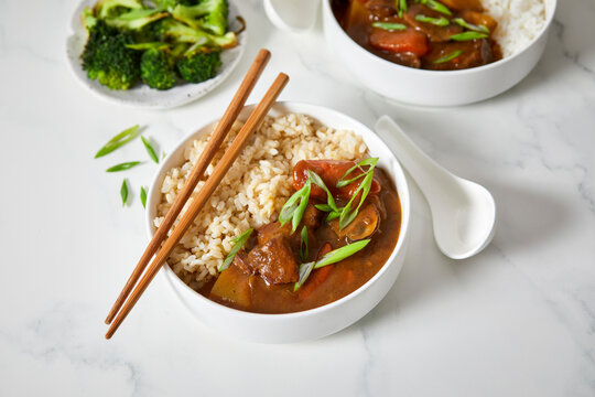 Japanese Curry with Brown Rice and Vegetables on a Light Background