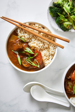 Japanese Curry with Brown Rice and Vegetables on a Light Background