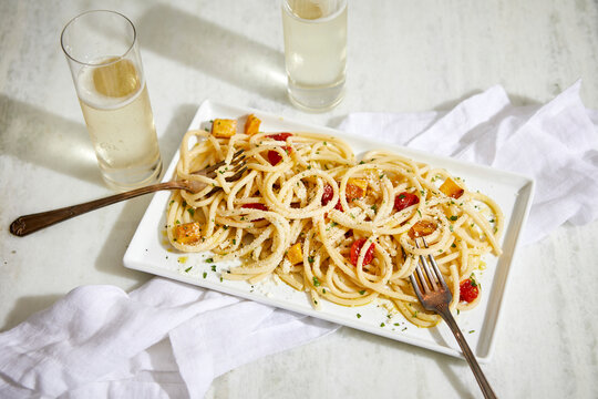 Bucatini Basta with Fresh Cherry Tomatoes and Squash and Glasses of Champagne
