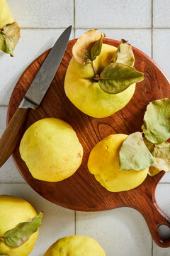 Quince Fruit on a Cutting Board and Tile Background